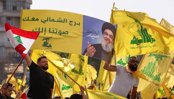 Supporters of Lebanon's Hezbollah leader Sayyed Hassan Nasrallah hold flags during an election rally in Tyre, Lebanon